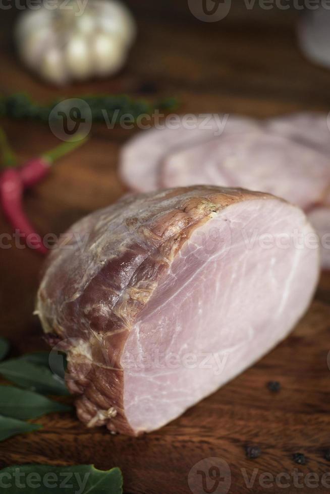 Pedaço de presunto fumado alemão tradicional caseiro natural na mesa de madeira foto