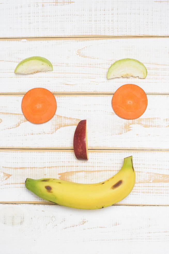 cara de frutas em fundo branco de madeira foto