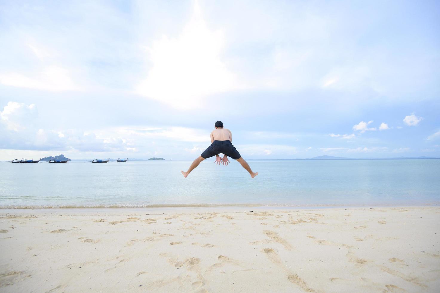 homem feliz curtindo e relaxando no conceito de praia, verão e férias foto