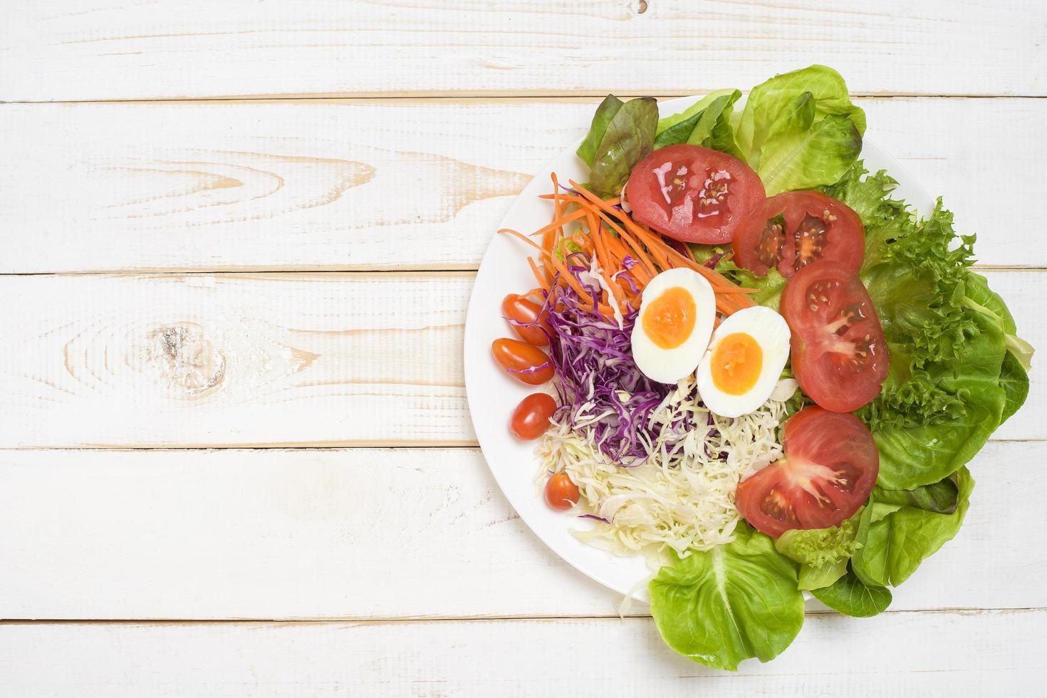 salada de legumes em fundo branco de madeira foto