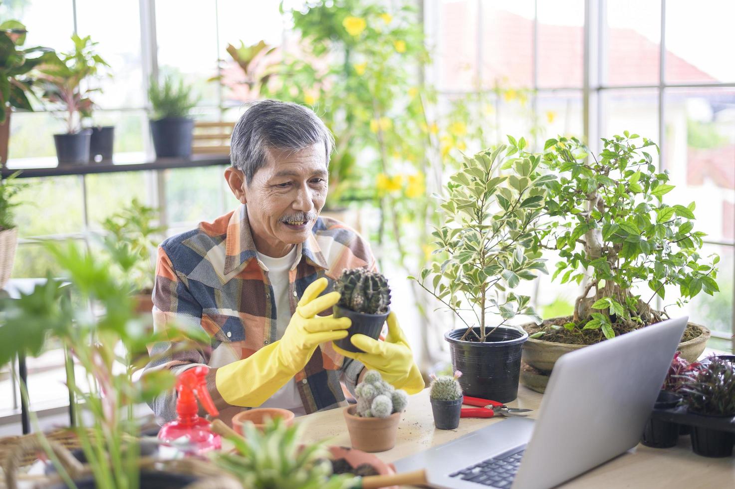 empresário sênior trabalhando com laptop apresenta plantas de casa durante transmissão ao vivo on-line em casa, vendendo conceito on-line foto