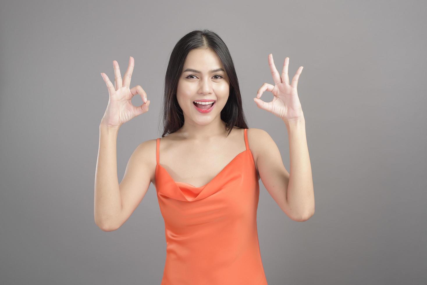 retrato da moda de uma linda mulher usando vestido laranja isolado sobre o estúdio de fundo cinza foto