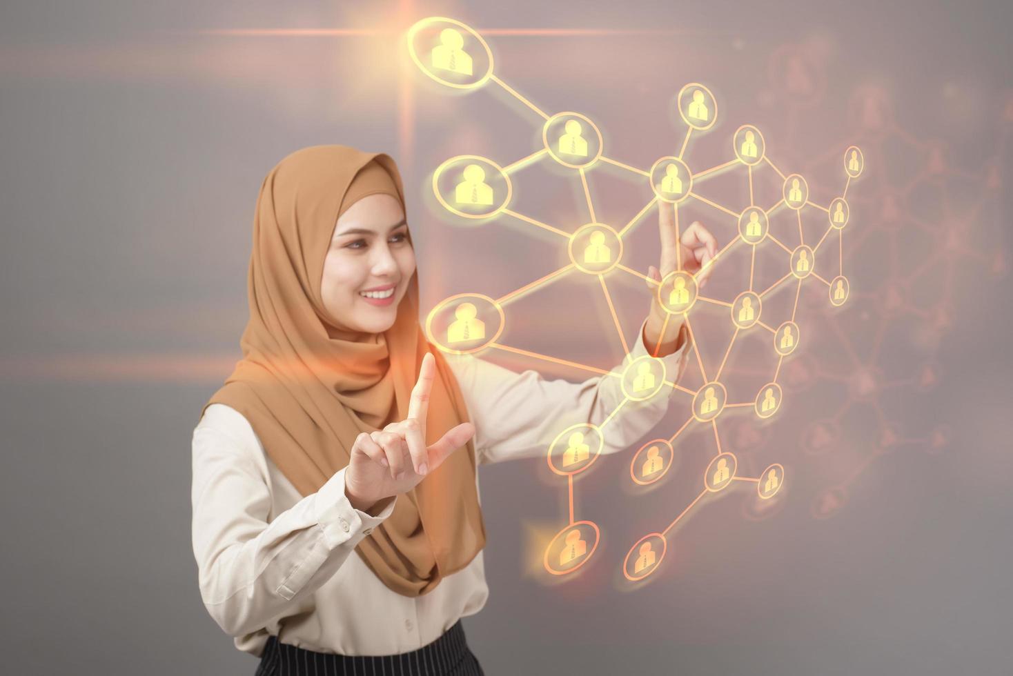 retrato de mulher bonita com hijab está tocando a tela virtual em fundo cinza foto