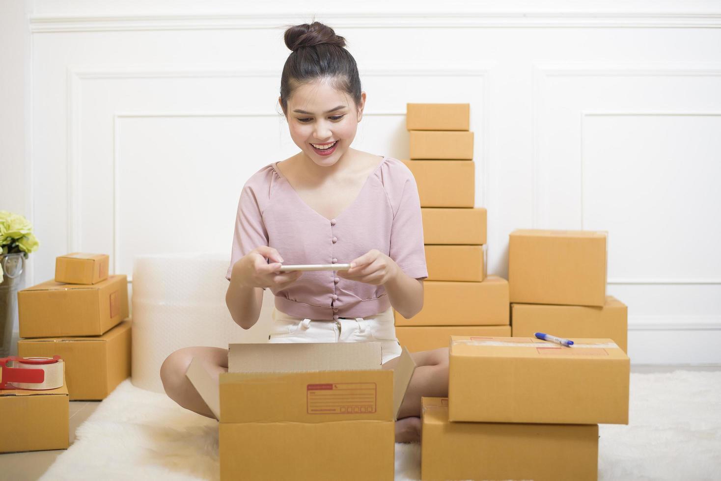 uma mulher está preparando produtos com caixas de papelão para envio. foto