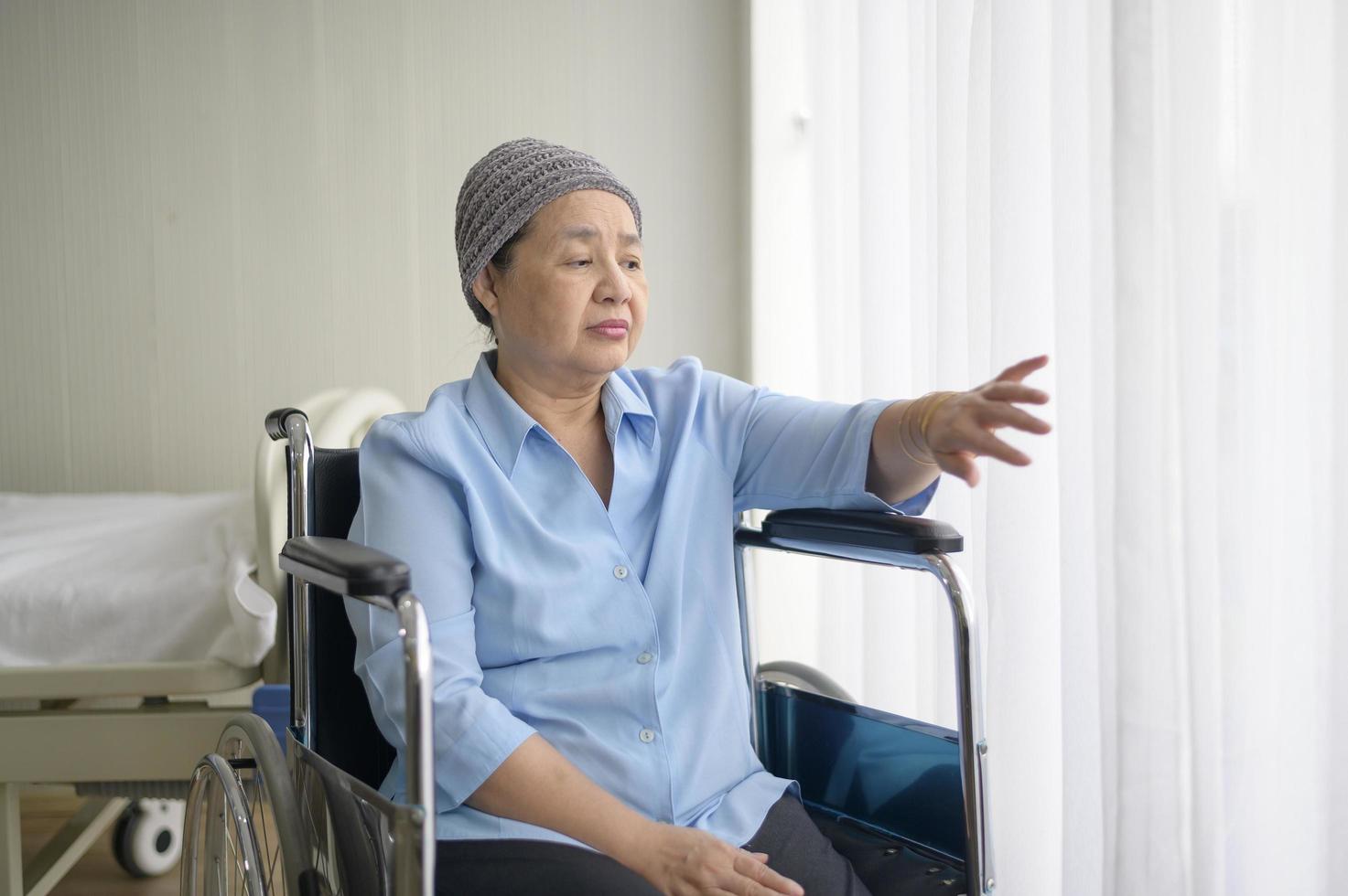 mulher de paciente de câncer asiático deprimido e sem esperança usando lenço na cabeça no hospital. foto