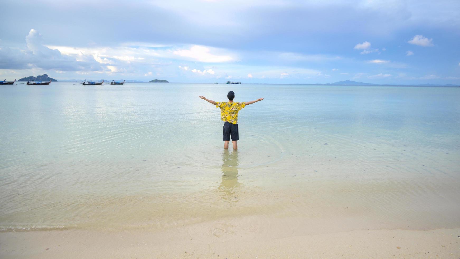 homem feliz curtindo e relaxando no conceito de praia, verão e férias foto