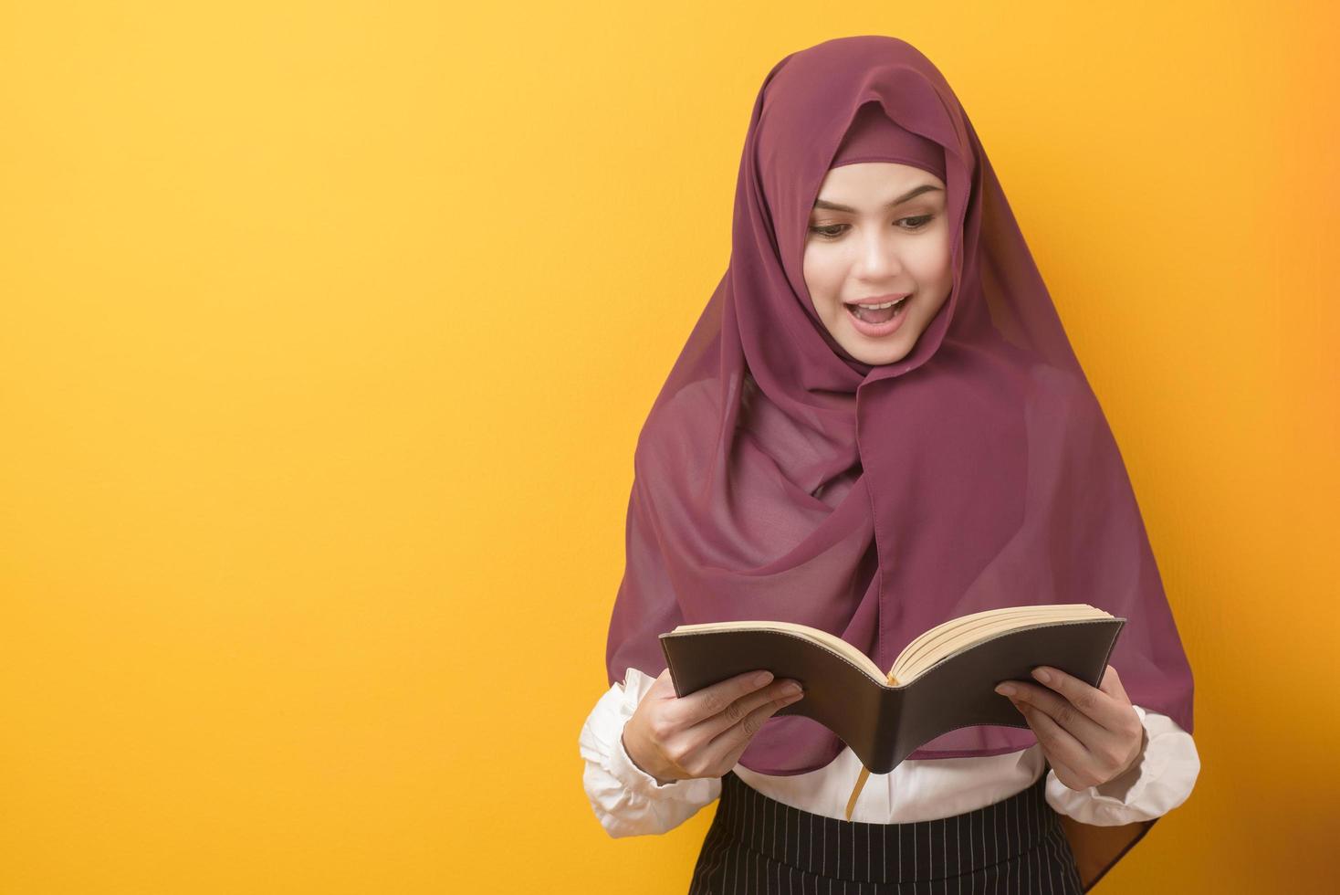 bela estudante universitária com retrato de hijab em fundo amarelo foto