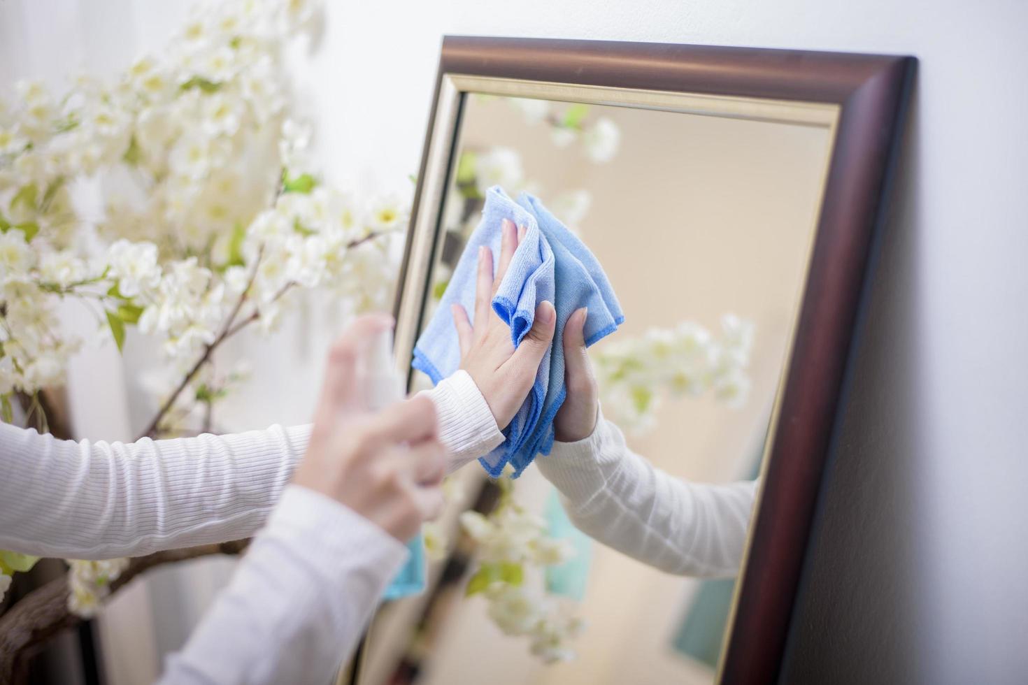 mulher está limpando a casa com spray de álcool foto