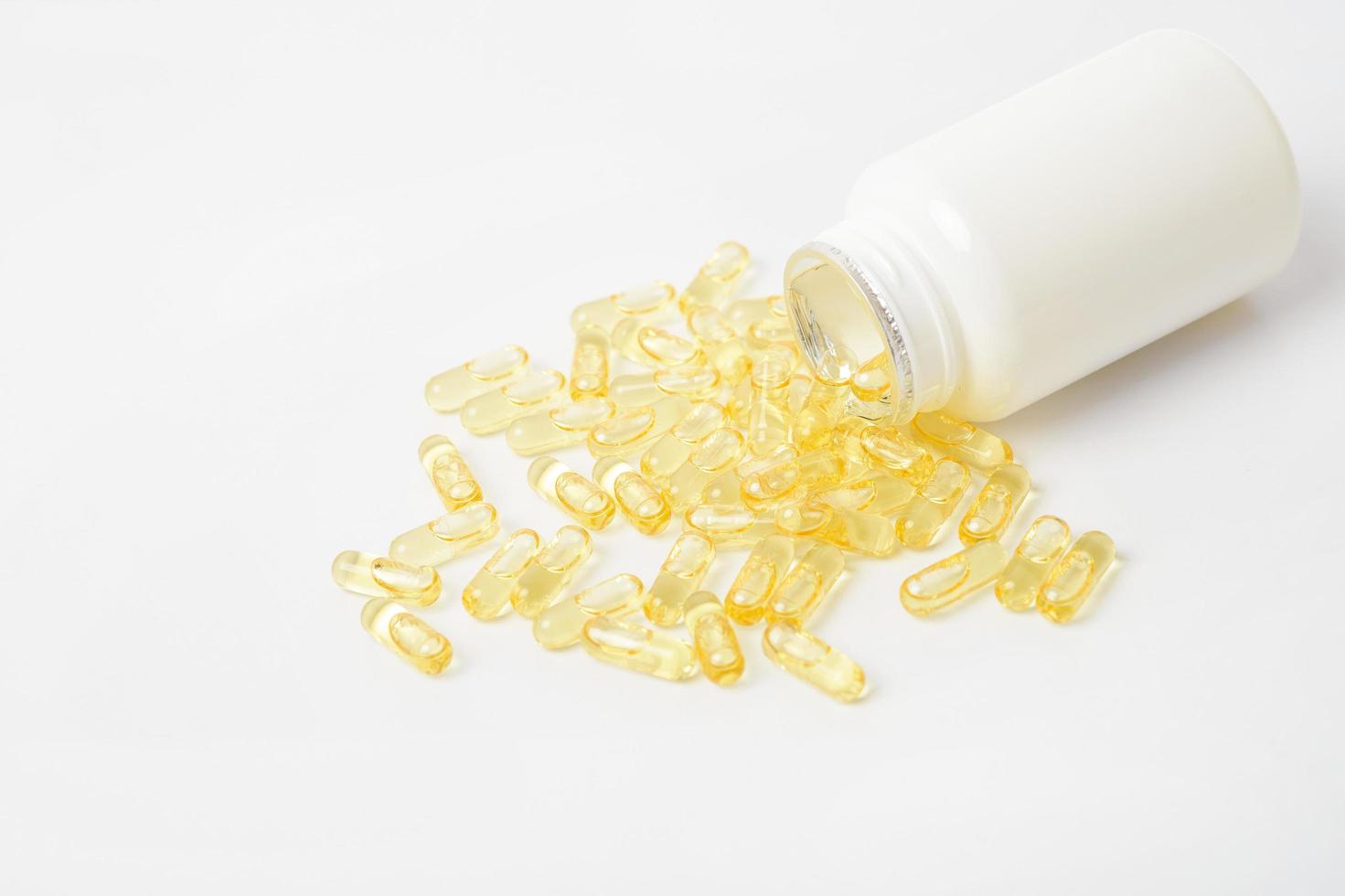 montes de pílulas de vitaminas amarelas no fundo branco foto
