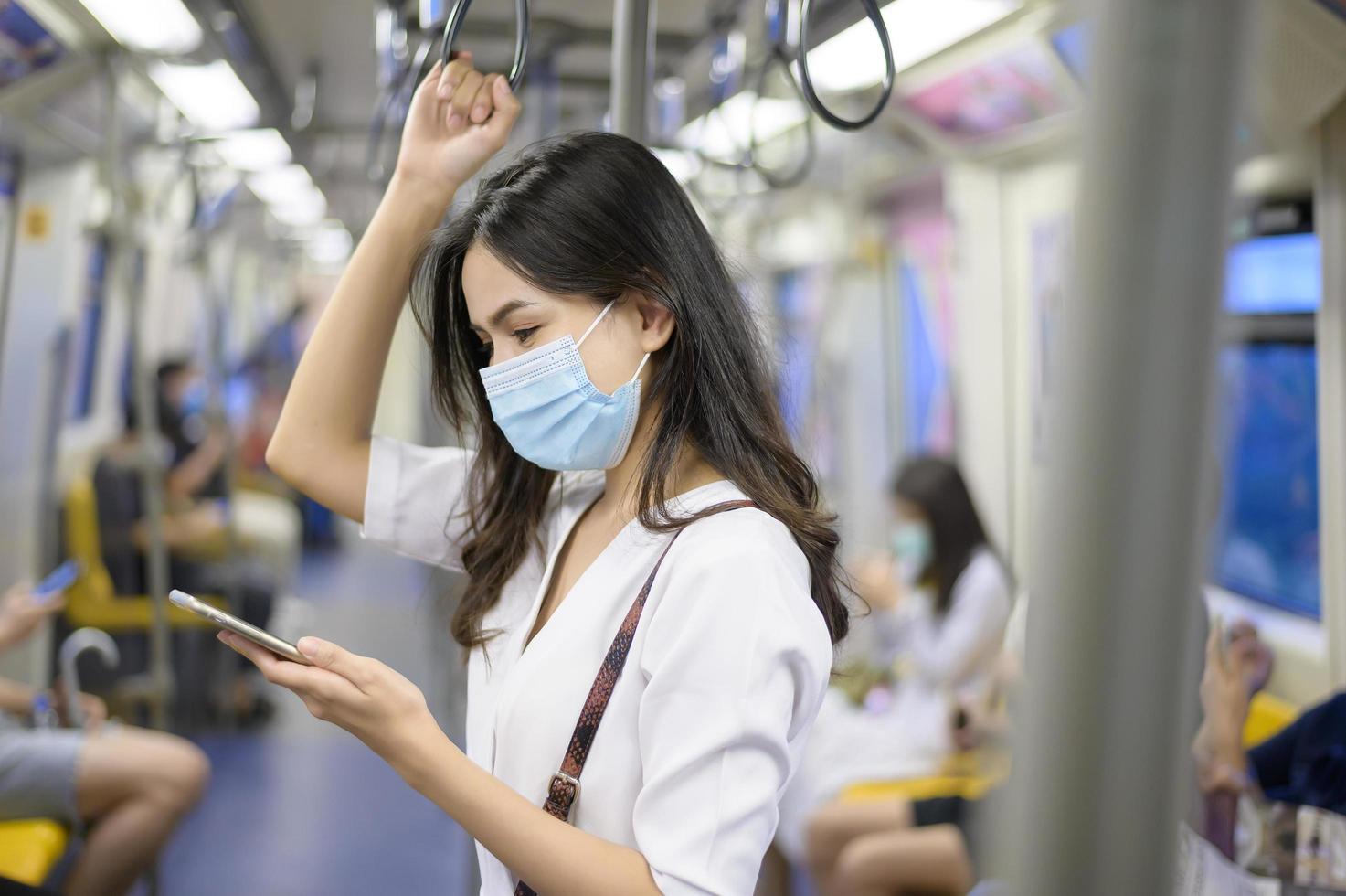 uma jovem está usando máscara protetora no metrô, proteção covid-19, viagens de segurança, novo normal, distanciamento social, transporte de segurança, viagens sob o conceito de pandemia. foto