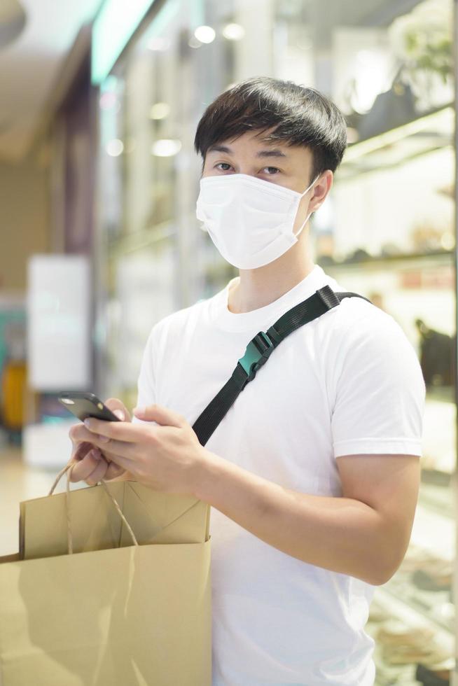 retrato de homem está usando máscara facial no shopping foto