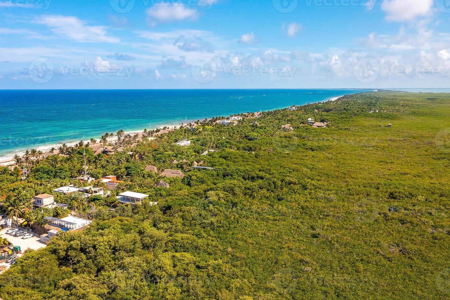 costa aérea de tulum na praia com um mar mágico do caribe e pequenas cabanas na costa. foto