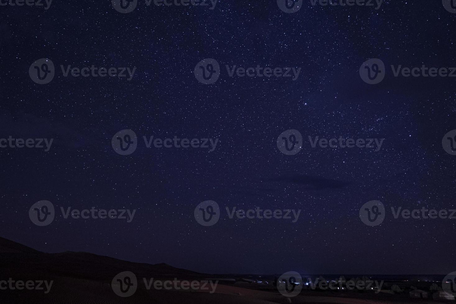 incrível vista do céu estrelado acima da paisagem do deserto durante a noite foto