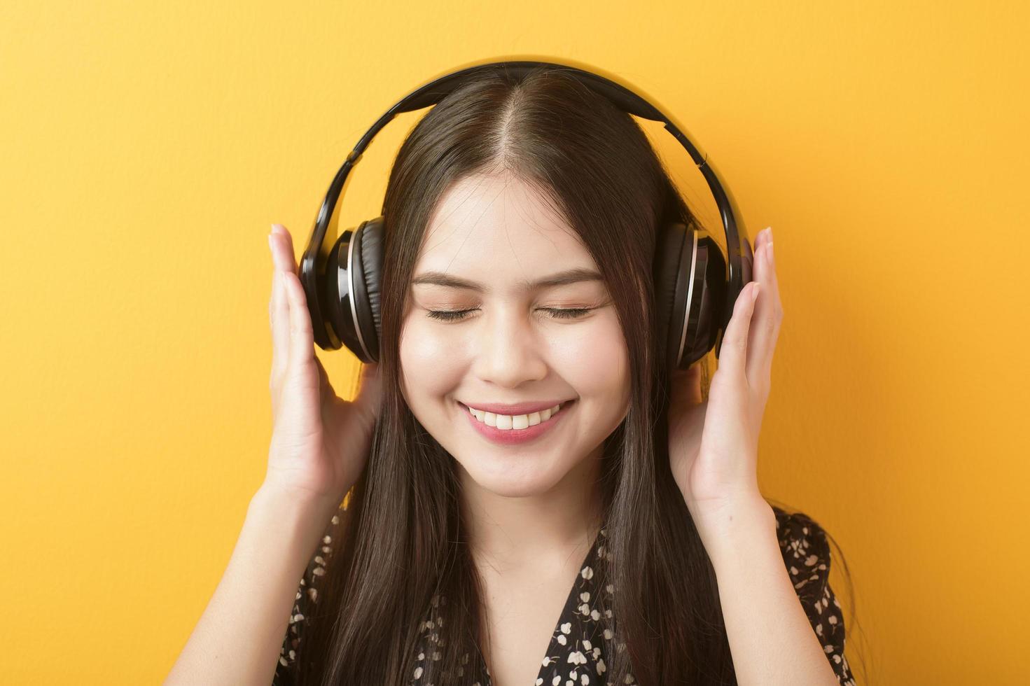 mulher amante da música está desfrutando com fone de ouvido em fundo amarelo foto