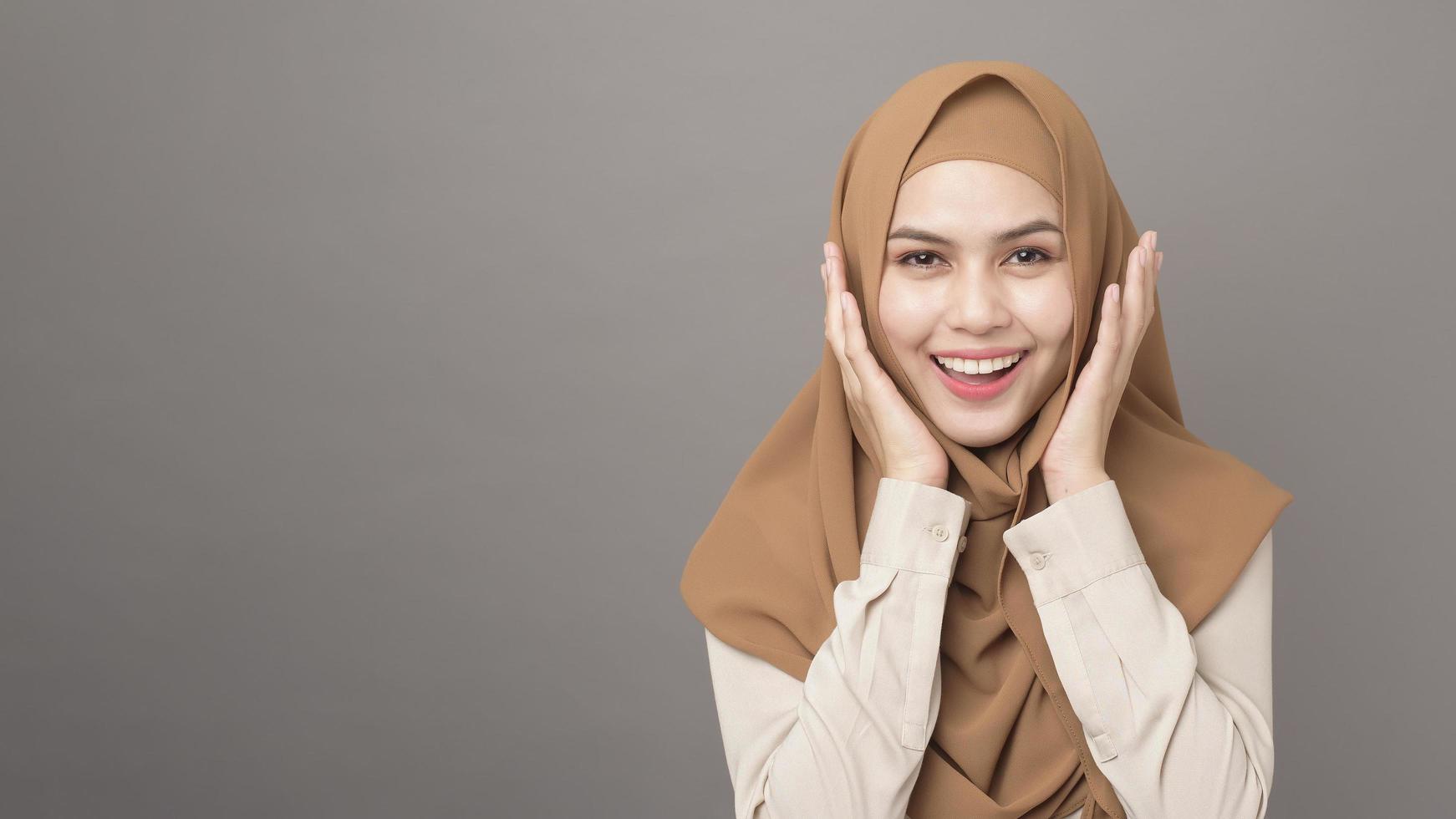 retrato de mulher bonita com hijab está sorrindo em fundo cinza foto