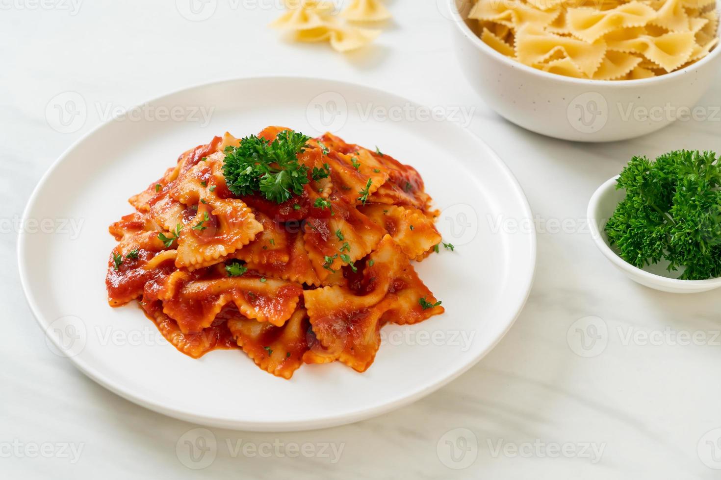 macarrão farfalle em molho de tomate com salsa foto