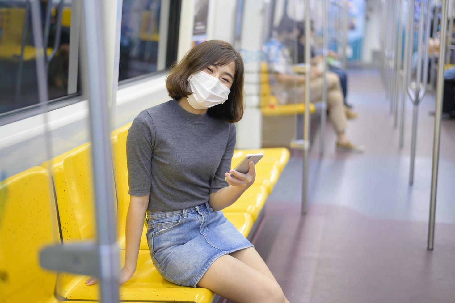 jovem está usando máscara protetora no metrô, proteção covid-19, viagens de segurança, novo normal, distanciamento social, transporte de segurança, viagens sob o conceito de pandemia. foto