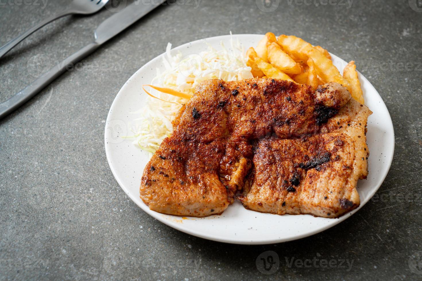 Bife de porco churrasco picante grelhado com batatas fritas foto