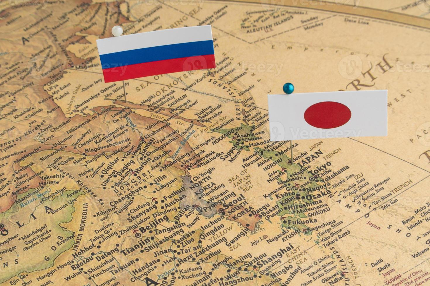 as bandeiras da rússia e do japão no mapa do mundo. fotografia conceitual, diferenças políticas devido à ilha de Sakhalin foto