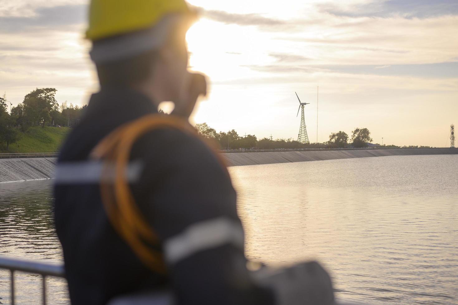 um engenheiro masculino usando um capacete protetor ao pôr do sol, foco seletivo no fundo foto