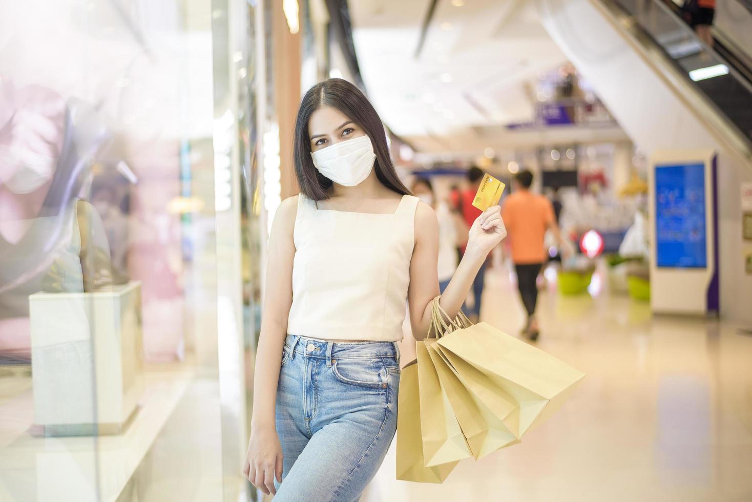retrato de mulher bonita está usando máscara facial no shopping foto