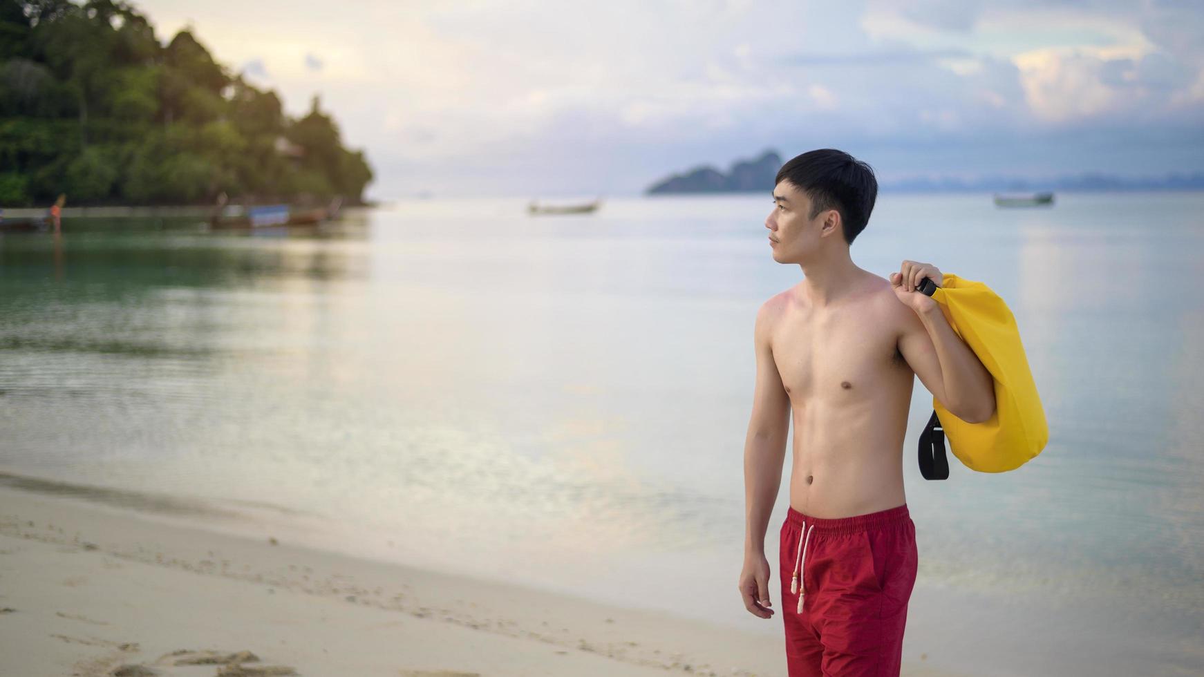 homem feliz curtindo e relaxando no conceito de praia, verão e férias foto