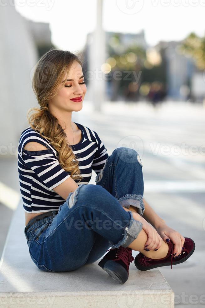 mulher loira engraçada pulando no meio urbano. foto