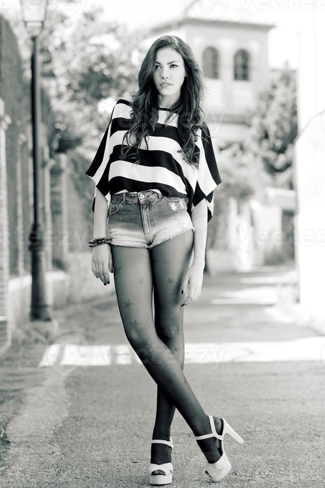 mulher atraente com shorts jeans em background urbano foto