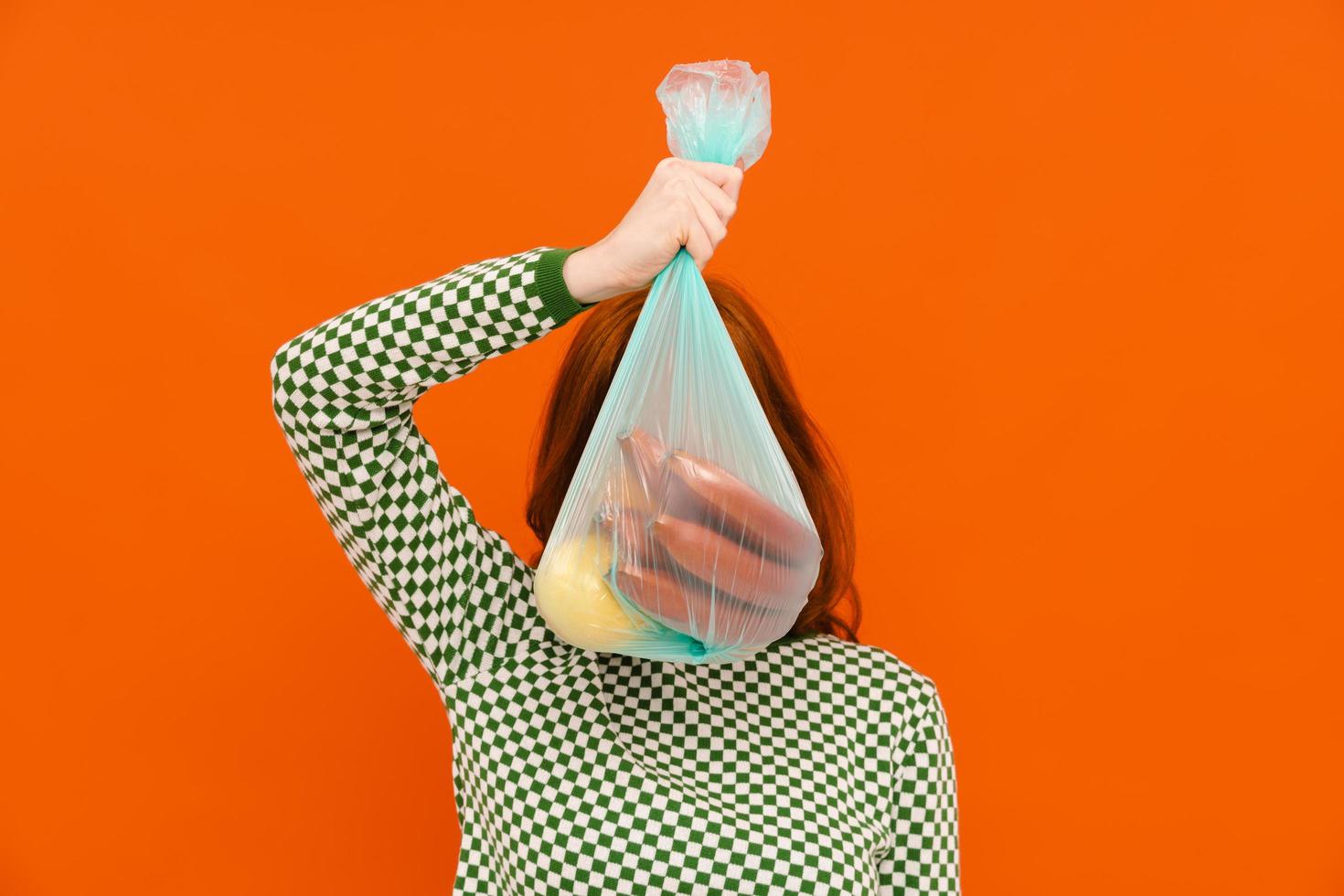 jovem segurando saco de lixo de plástico foto