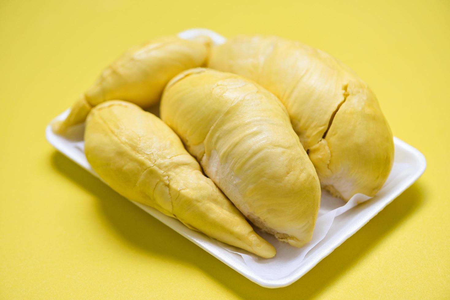 frutas durian frescas de casca de árvore na bandeja de plástico e fundo amarelo - verão de frutas tropicais durian maduras para sobremesa doce ou lanche na tailândia foto