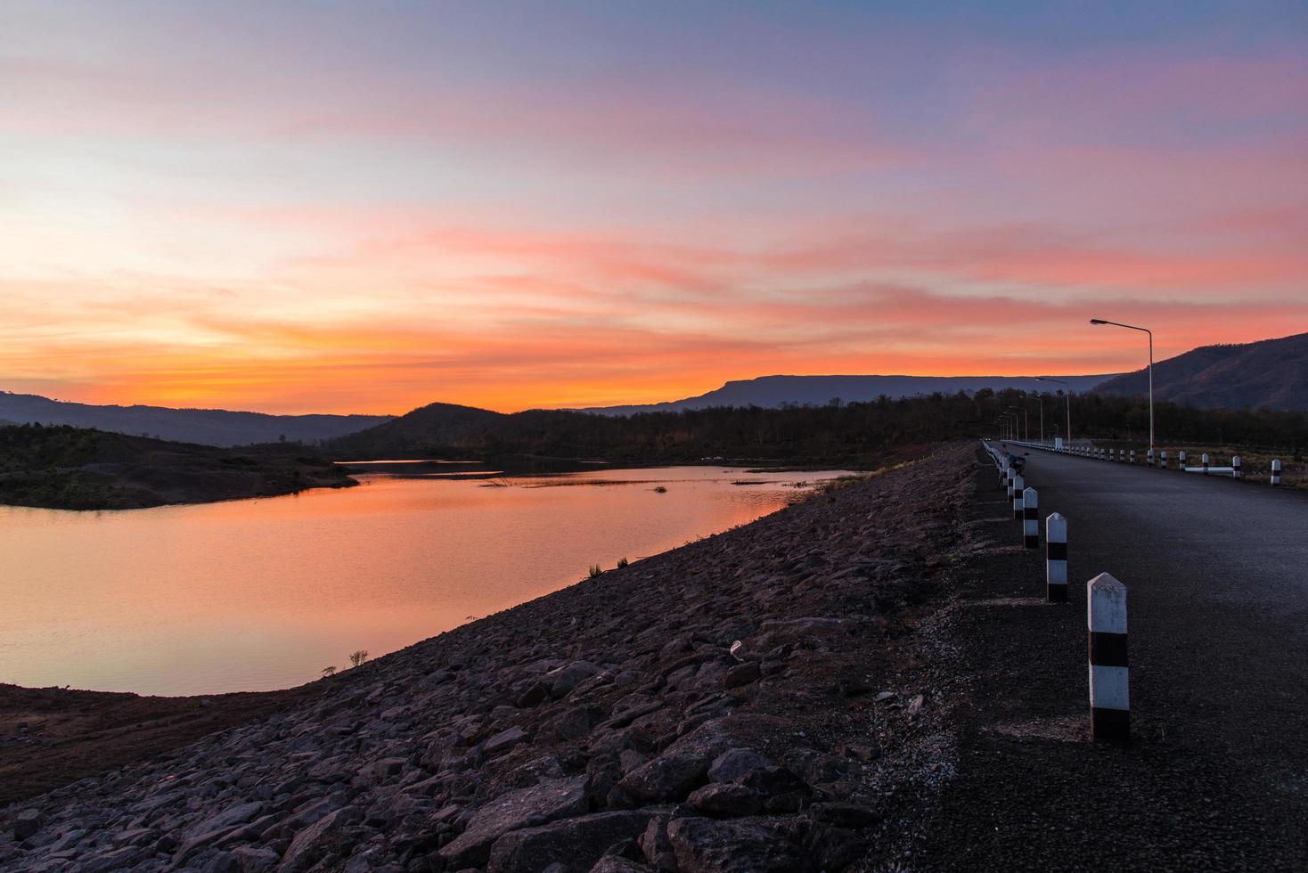 crepúsculo céu rio pôr do sol roxo e laranja cor paisagem lago noite nuvens e montanhas foto