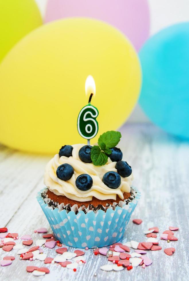 cupcake com uma vela numeral seis foto
