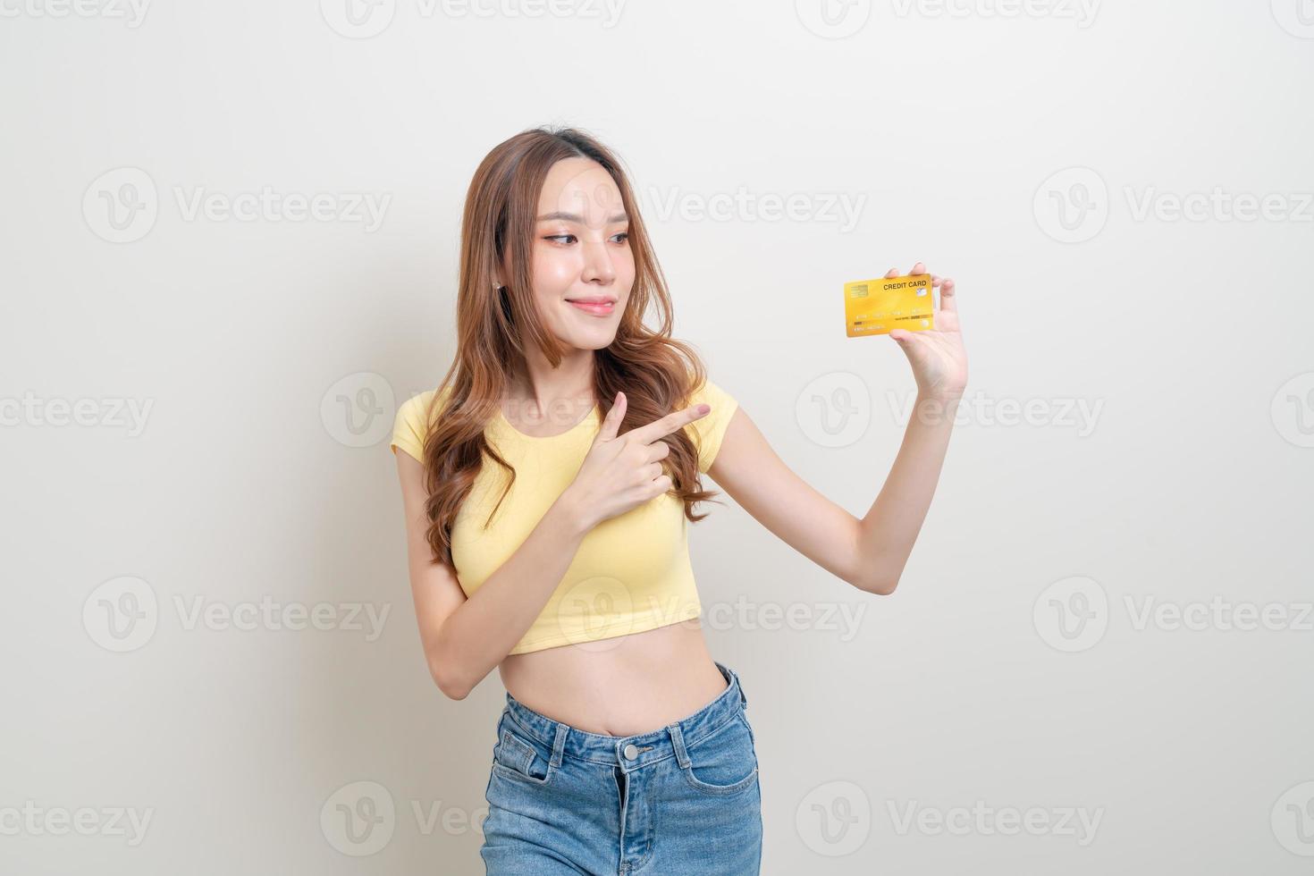 retrato linda mulher asiática segurando um cartão de crédito foto