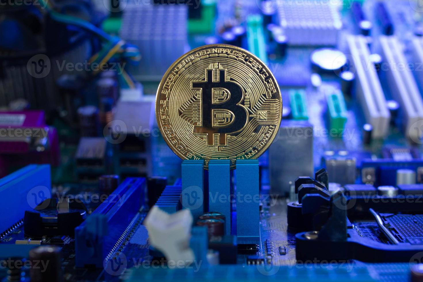 moeda de bitcoin dourada em um fundo claramente visível de microchips e componentes de rádio em luz azul. novo conceito de criptomoeda digital da indústria blockchain. fechar-se. foto