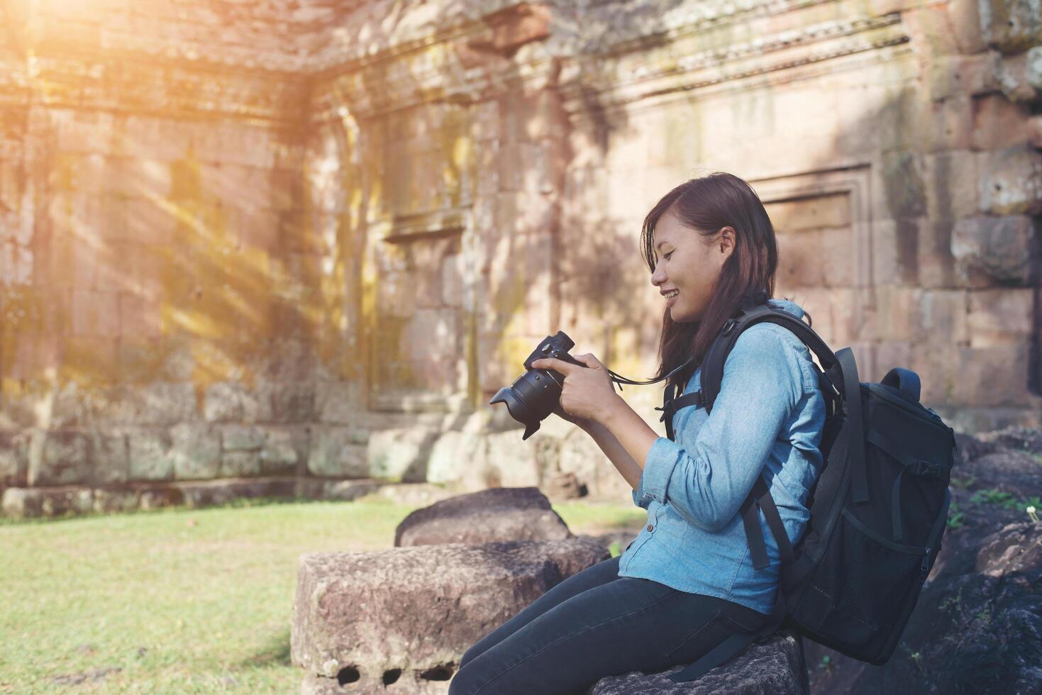 turista de fotógrafo jovem mulher atraente com mochila vindo para tirar fotos no antigo templo phanom degrau na tailândia.