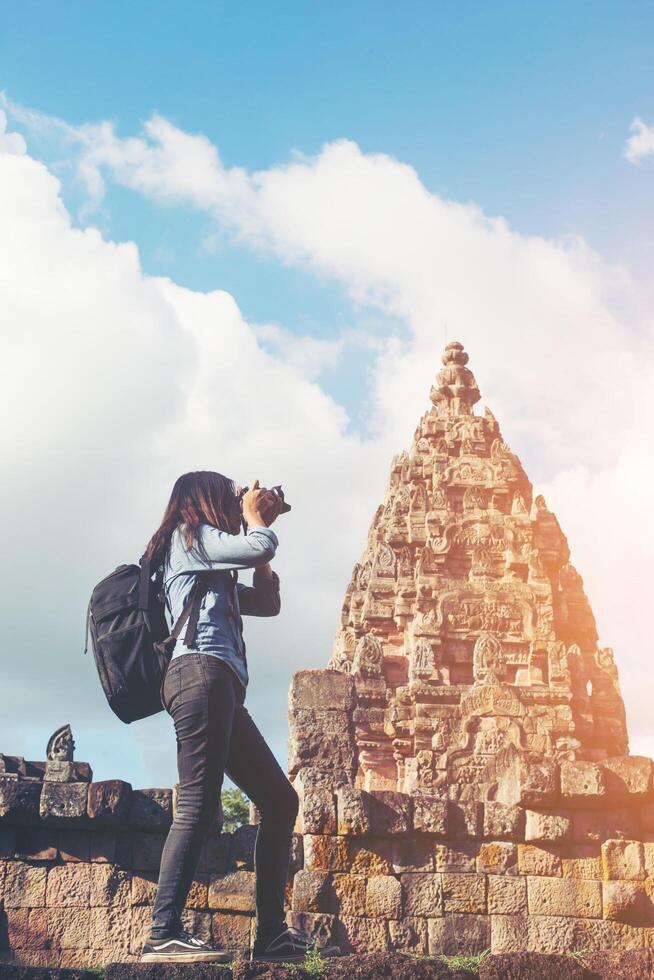 turista de fotógrafo jovem mulher atraente com mochila vindo para tirar fotos no antigo templo phanom degrau na tailândia.