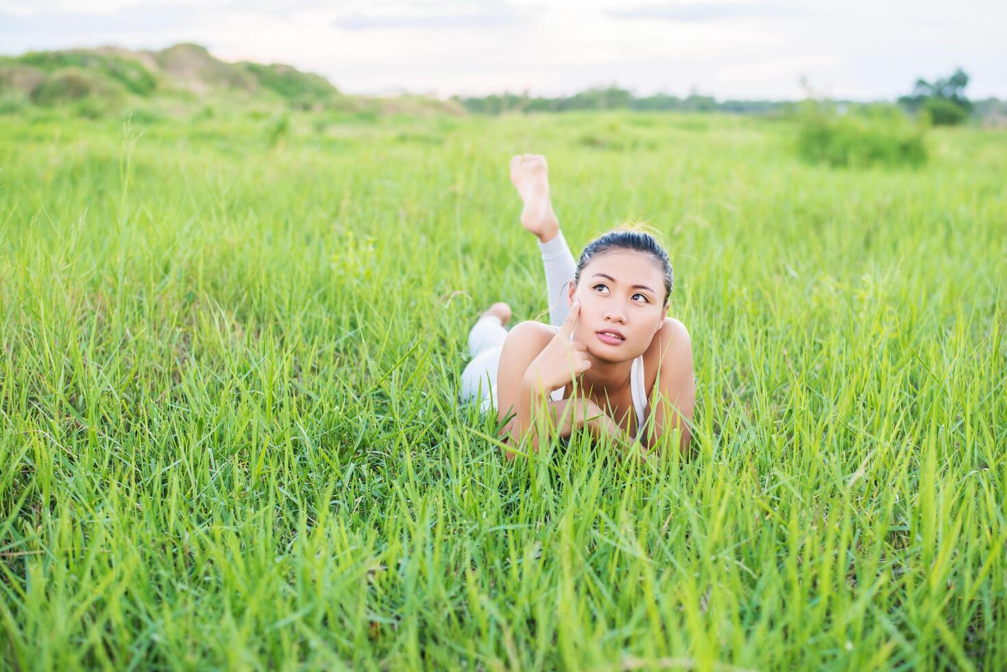 mulher jovem e bonita, mulher sorridente saudável relaxante na grama verde em prados. foto