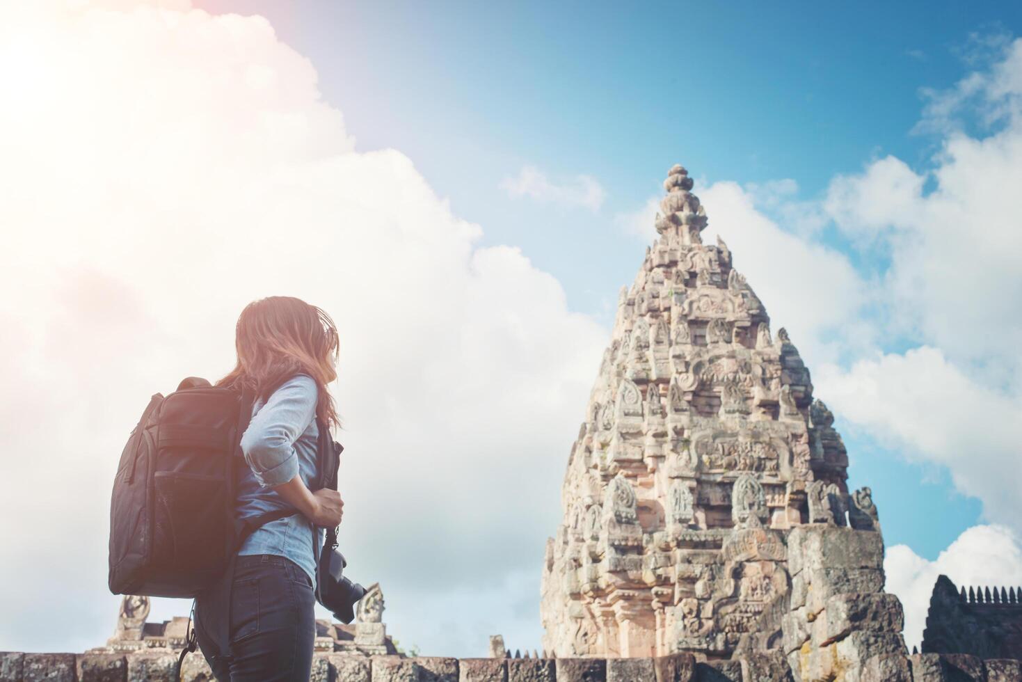 turista de fotógrafo jovem mulher atraente com mochila vindo para tirar fotos no antigo templo phanom degrau na tailândia.