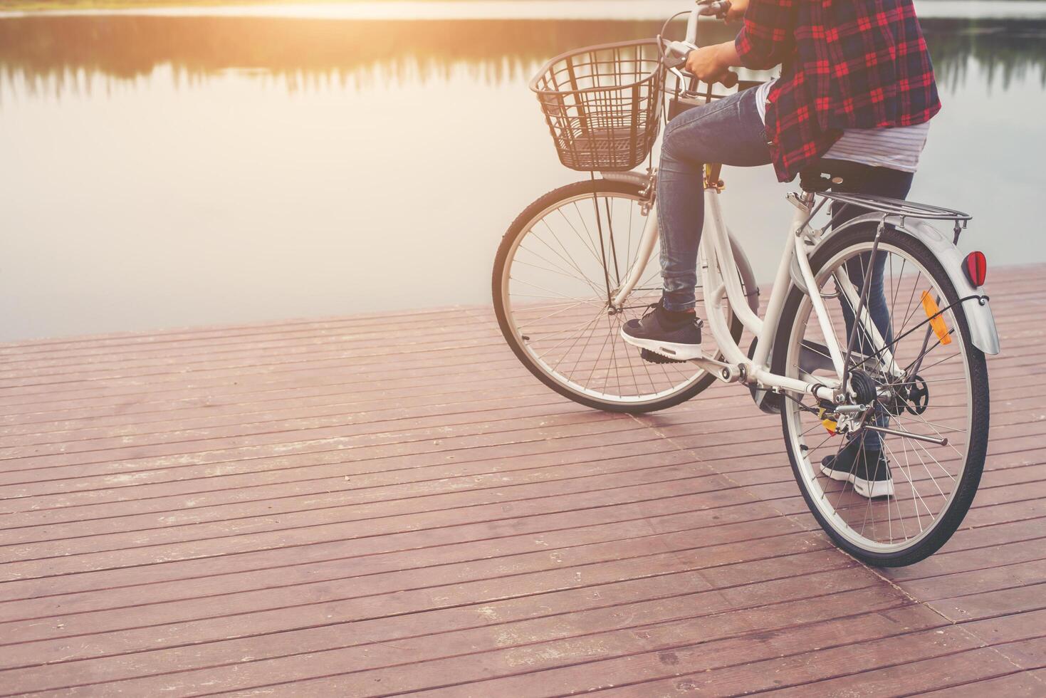 close-up de mulher jovem hippie segurando o pé no pedal da bicicleta. foto