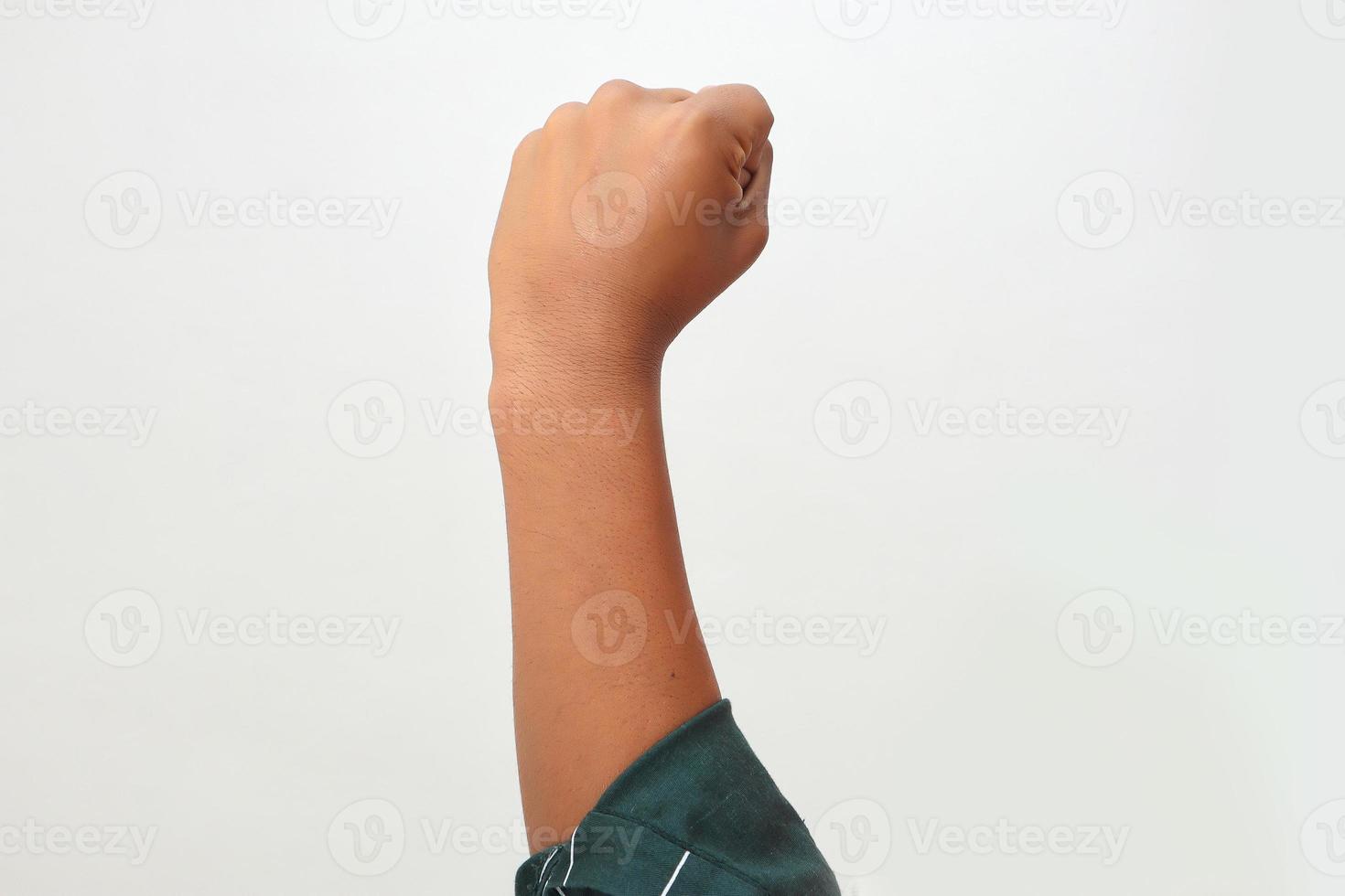 close-up da mão do jovem homem caucasiano sobre fundo isolado fazendo gesto de protesto e revolução, punho expressando força e poder foto