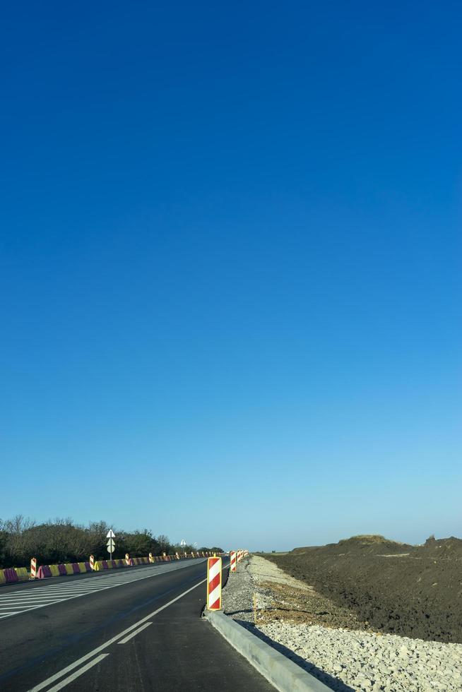 paisagem com uma estrada em construção sob um céu azul. foto