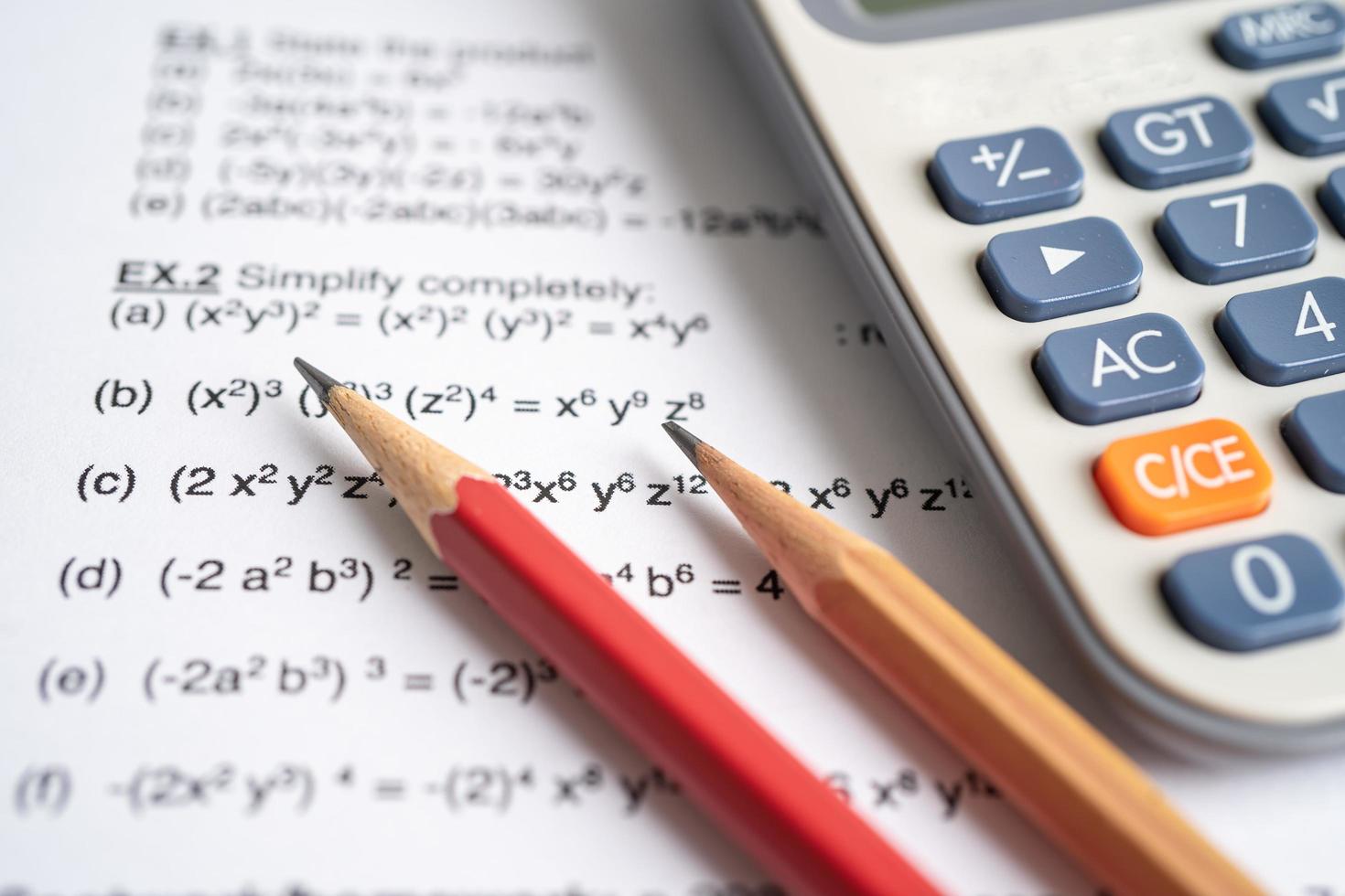 lápis e calculadora no papel de teste de exercício de fórmula matemática na escola de educação. foto