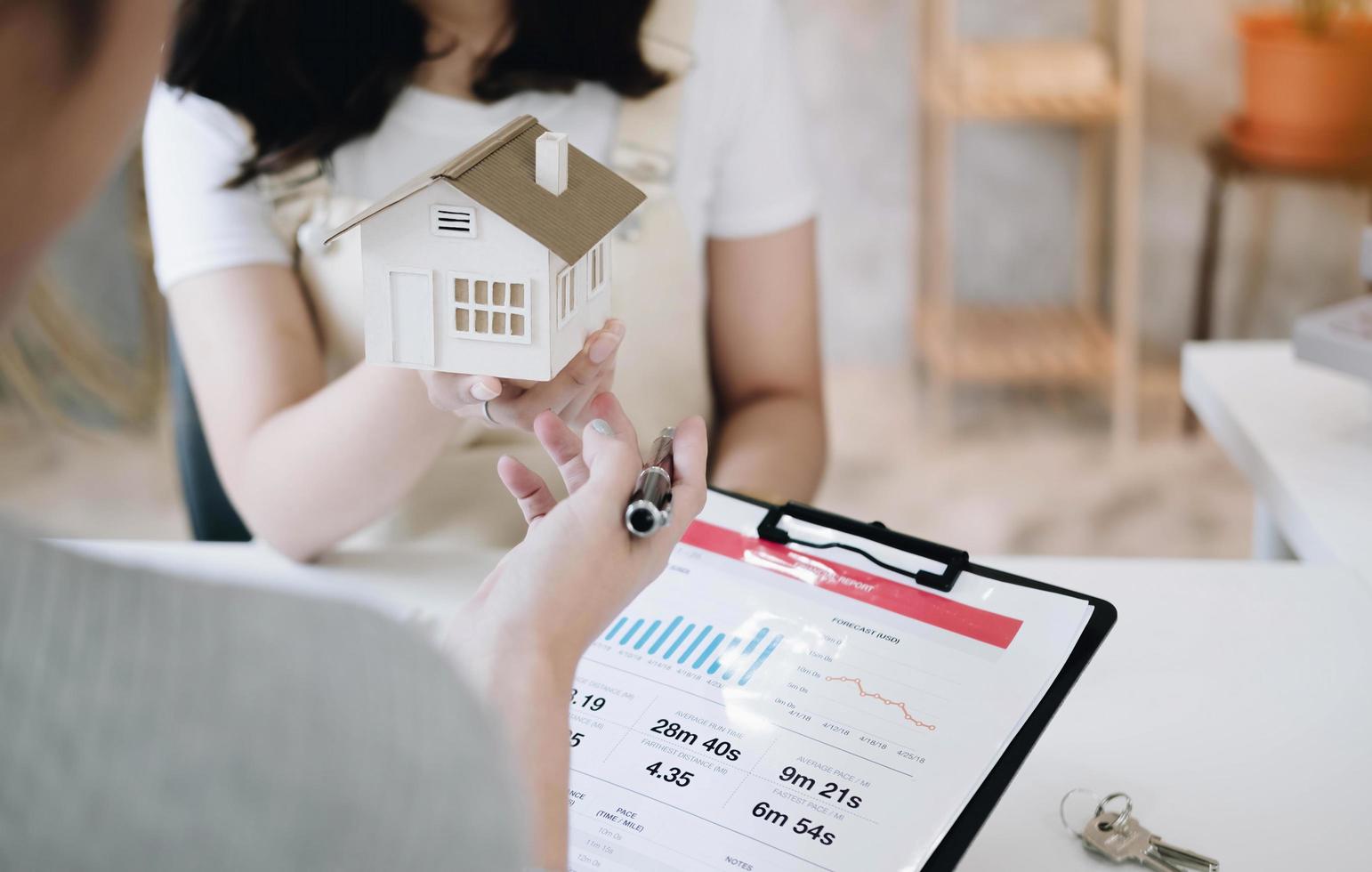 corretor de imóveis apresentando e consultando o cliente para tomada de decisão assinar contrato de formulário de seguro, modelo de casa, sobre oferta de empréstimo hipotecário e seguro de casa. foto