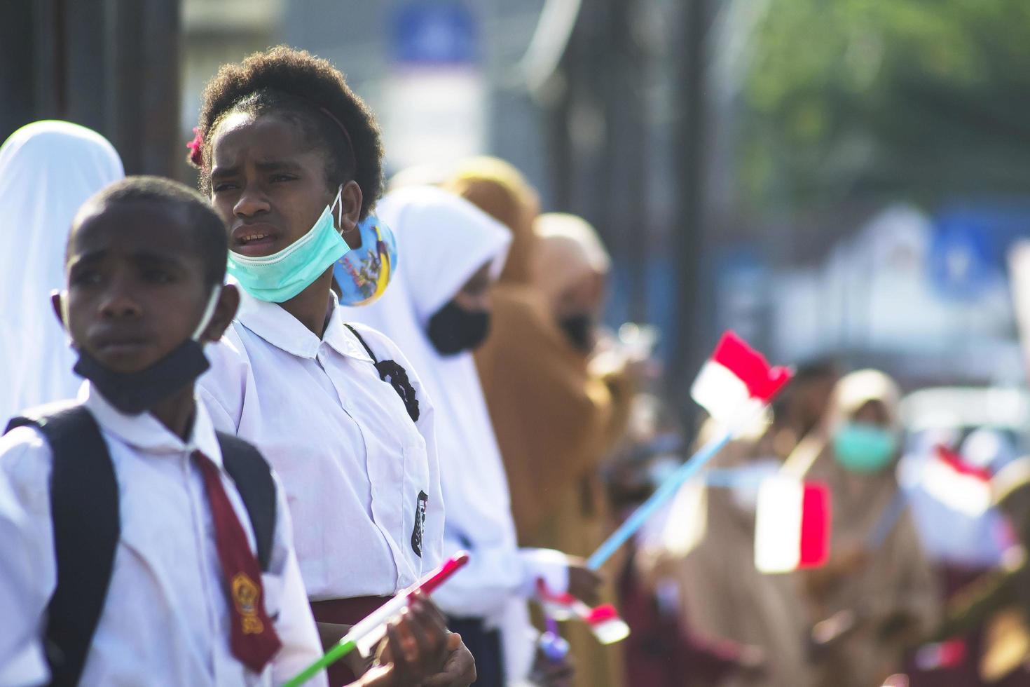 sorong, papua ocidental, indonésia, 4 de outubro de 2021. visita de estado do presidente da indonésia, joko widodo. crianças em idade escolar e professores saudaram a chegada do presidente da beira da estrada. foto