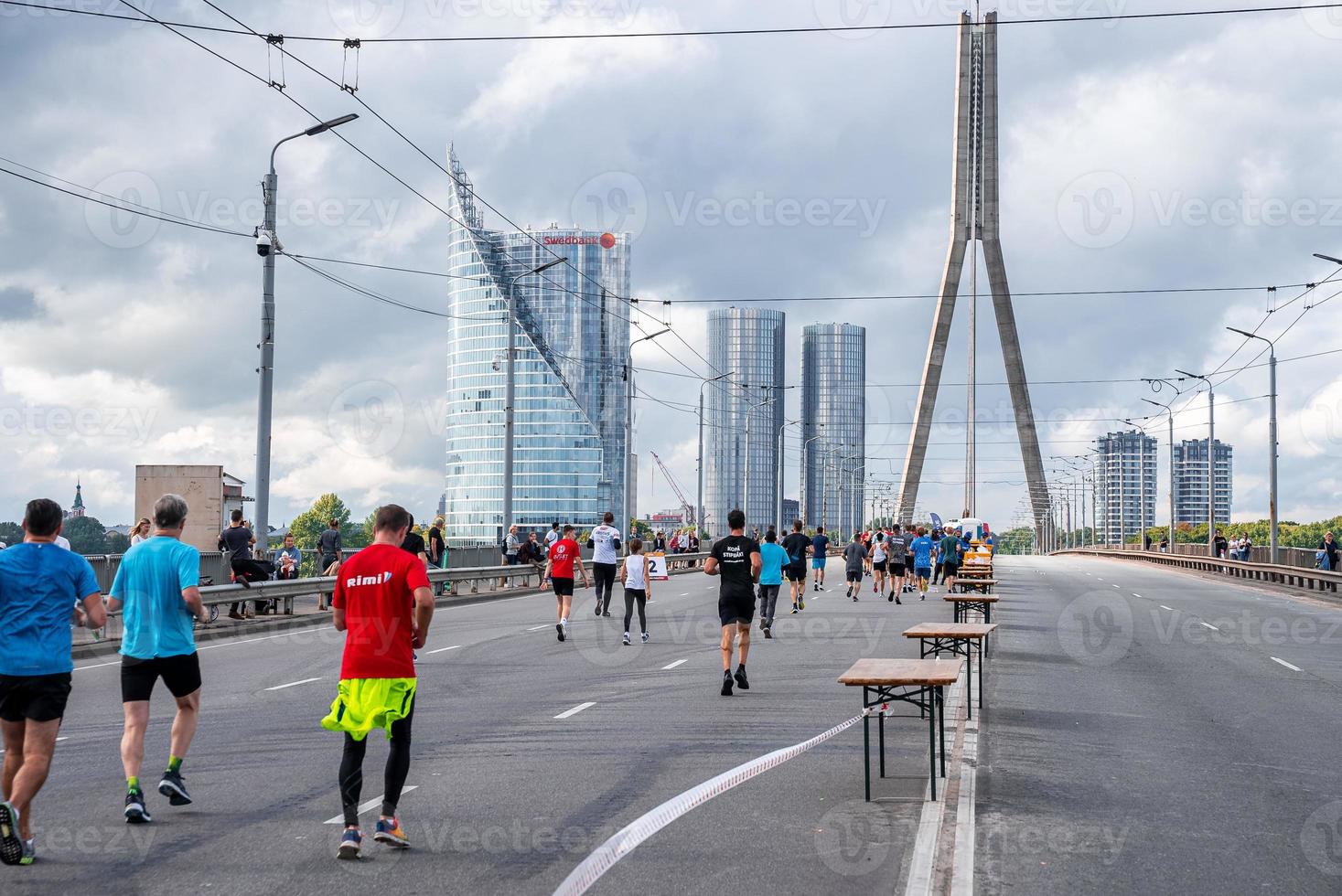 corredores atravessando as ruas de riga durante a maratona de tet riga. foto