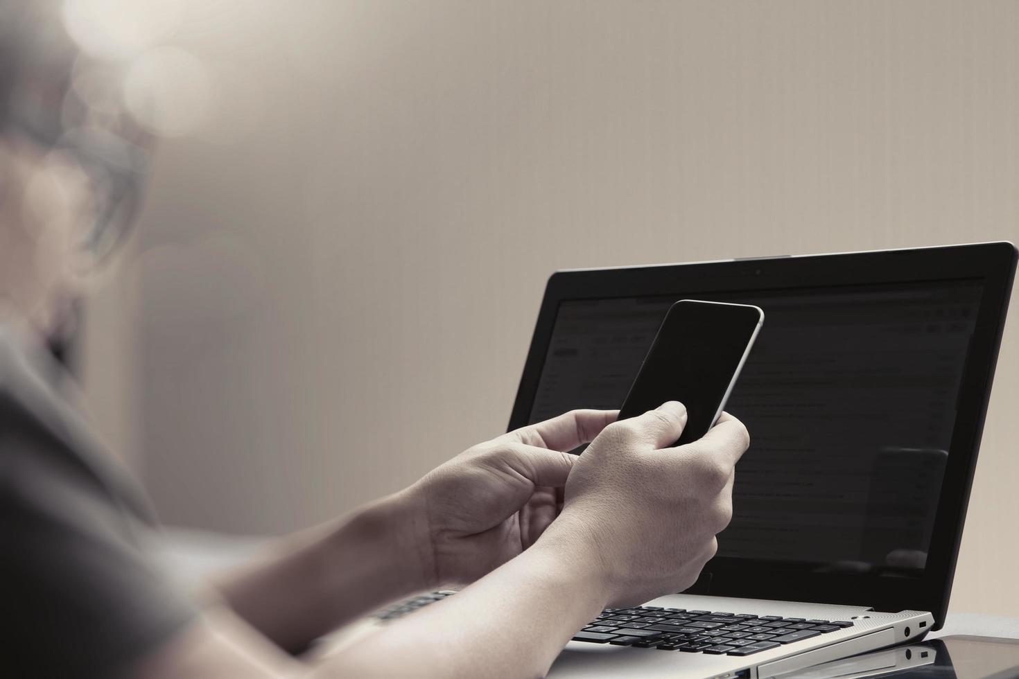 trabalhando com telefone inteligente e computador na cama como conceito foto