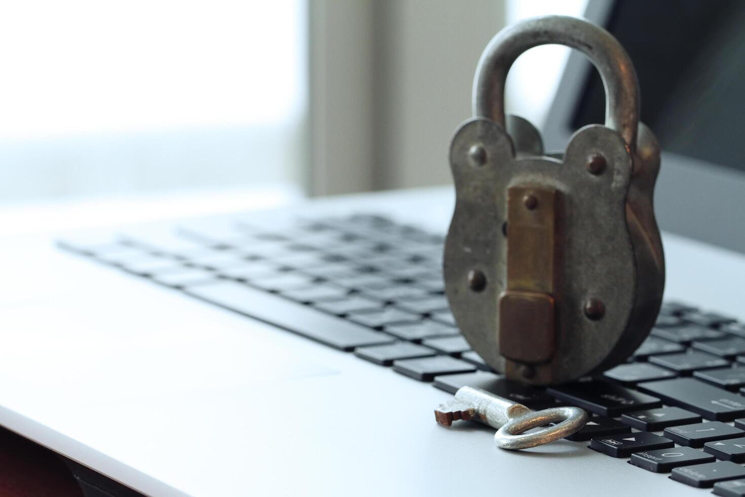 cadeado e chave velhos do conceito de segurança de internet no teclado do computador portátil foto