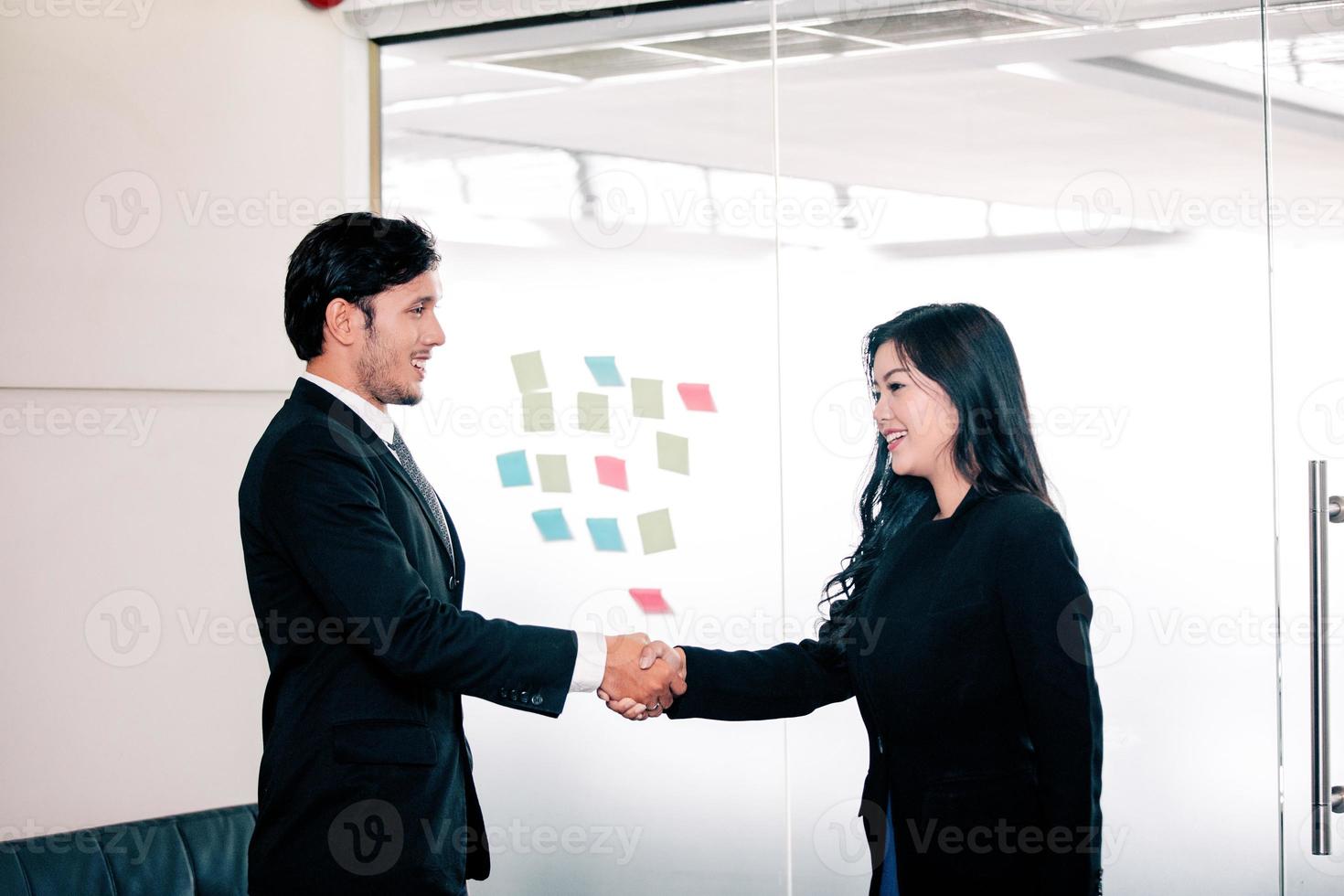 empresários apertando as mãos e sorrindo concordando em assinar contrato e encerrar uma reunião foto