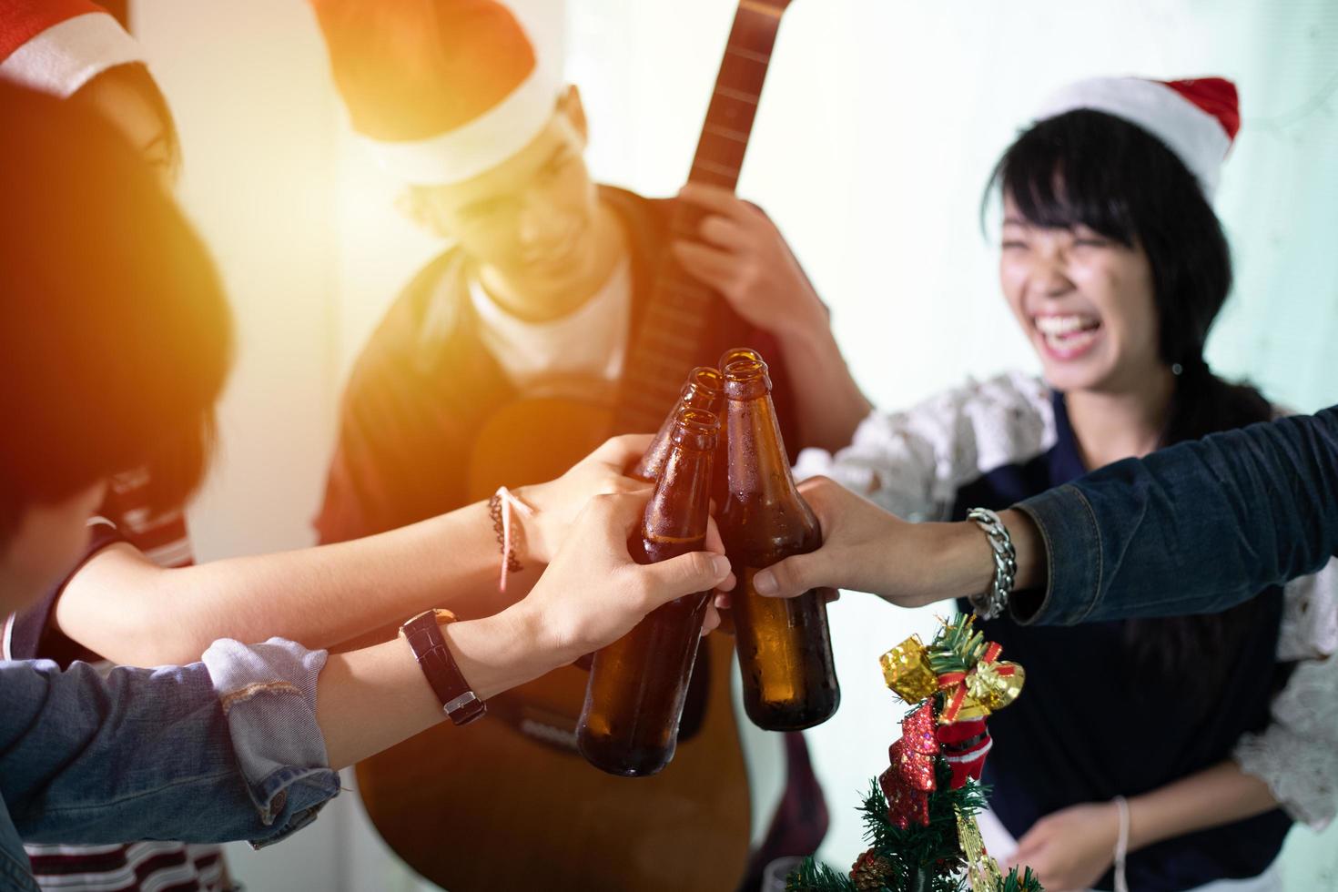 grupo asiático de amigos festejando com bebidas alcoólicas de cerveja e jovens desfrutando em um bar brindando coquetéis foto