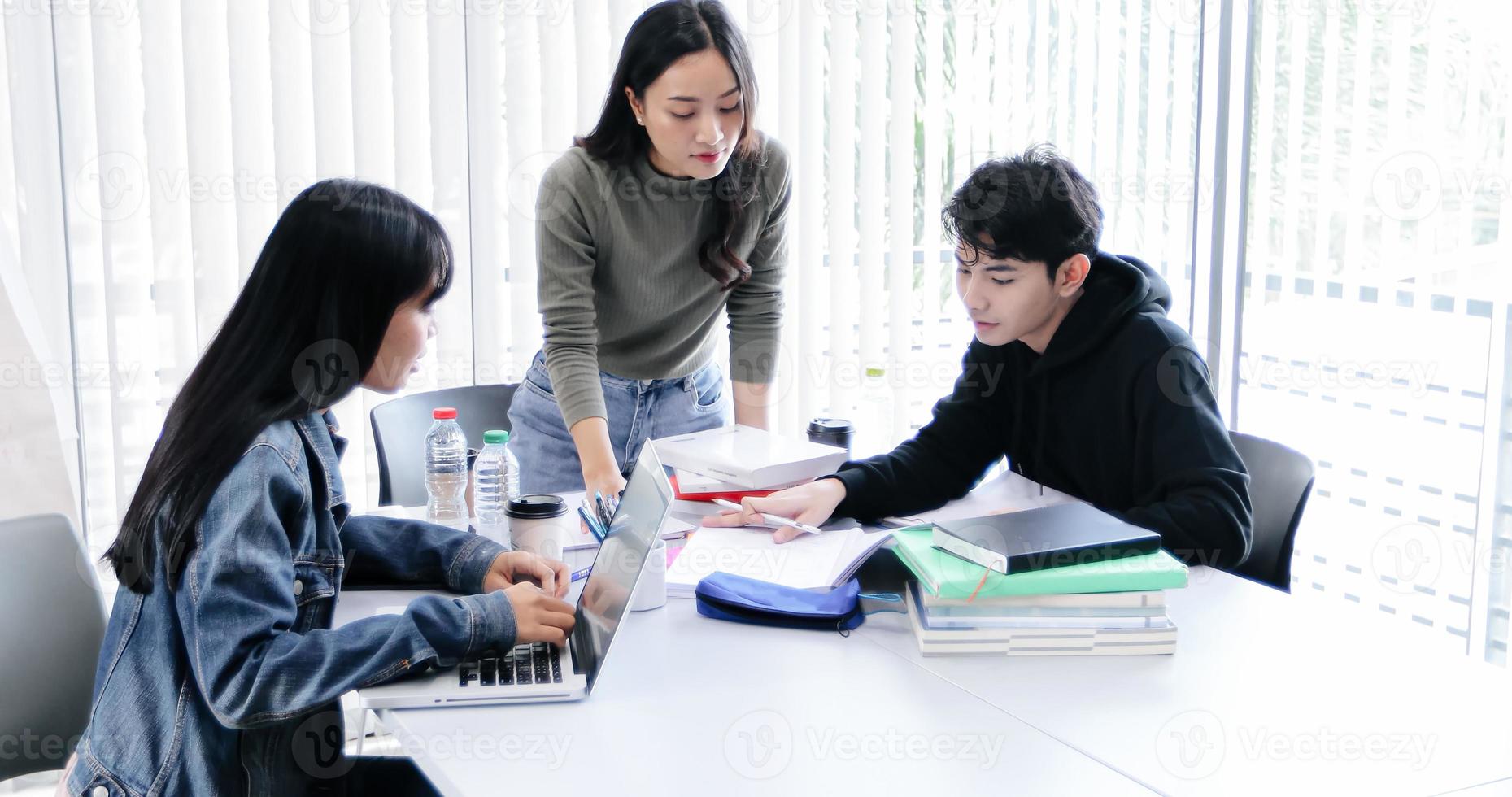 os alunos do grupo sorriem e se divertem e usando o tablet também ajuda a compartilhar ideias no trabalho e no projeto. e também revisar o livro antes do exame foto